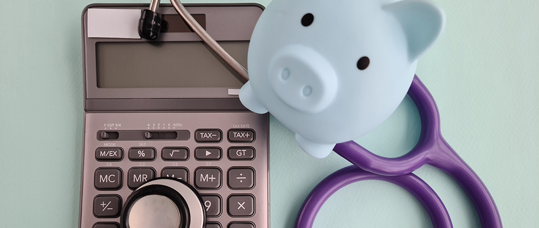 Calculator, piggy bank, and stethoscope grouped together