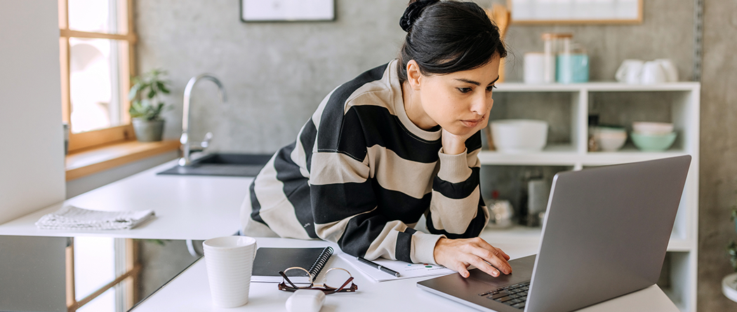 woman intently looking at laptop screen