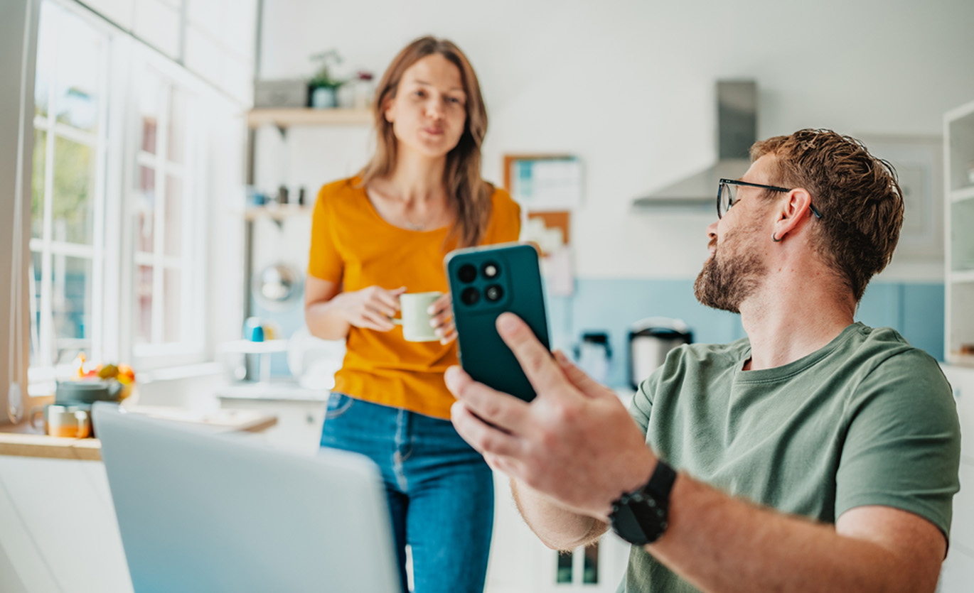 husband casually shows his wife something on his phone